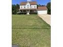 Charming two-story home featuring a welcoming front porch and well-maintained landscaping at 5458 Stagecoach Rd, Ellenwood, GA 30294