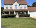 Charming two-story home featuring a welcoming front porch and well-maintained landscaping at 5458 Stagecoach Rd, Ellenwood, GA 30294