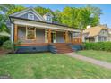 Charming renovated home with inviting front porch, brick walkway, and mature trees on a lush green lawn at 378 Grant Park Se Pl, Atlanta, GA 30315