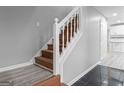 Interior staircase with wooden steps and white railings, leading to an open kitchen area at 3941 Kings Pl, Ellenwood, GA 30294