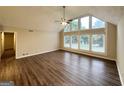 Bright living room features wood-look floors, a ceiling fan and large windows providing a great view at 4397 Bluebird Ln, Lithia Springs, GA 30122