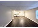 Spacious living room featuring modern wood flooring, neutral paint, and an open layout into the kitchen at 3995 Willowbrook Dr, Douglasville, GA 30135