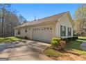 A long driveway leads to an attached two-car garage of a home with vinyl siding at 425 Wendy Ct, Mcdonough, GA 30252