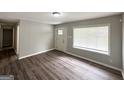 Living room showcasing wood-look flooring, large window, and neutral paint at 830 Mercury Dr, Atlanta, GA 30331