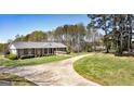 Lovely brick home with a long driveway and well-maintained lawn, set amidst mature trees at 1092 E Lake Rd, Mcdonough, GA 30252