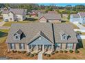 Aerial view of a charming single-story home featuring a brick facade, dormer windows, and manicured landscaping at 1141 Abundance Dr, Locust Grove, GA 30248