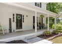 Inviting covered front porch features seating, greenery, and a welcoming entrance with a wreath and 'Welcome' sign at 1917 Lake Ridge Ct, Jonesboro, GA 30236