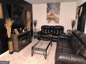 Comfortable living room with leather sofas, decorative fireplace, and an artistic flair at 99 Cooperton, Villa Rica, GA 30180