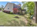 Expansive backyard features lush green grass, mature trees, and a spacious elevated deck at 120 Masters N Dr, Peachtree City, GA 30269