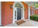 Close-up of the front door with sidelights, brick facade, exterior lights and a welcome mat at 127 Darwish Dr, Mcdonough, GA 30252