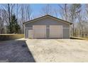 A sizable storage building, featuring a double roll-up door and pedestrian door, sits on a gravel foundation at 175 Laney Ct, Mcdonough, GA 30252