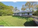 A charming single-story home with blue siding, brick foundation, set on a lush green lawn under a clear blue sky at 758 King Rd, Jonesboro, GA 30236