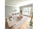 Bright living room features a large window, wood floors, and a comfortable seating arrangement at 1008 Stonekirk Trce, Lawrenceville, GA 30043