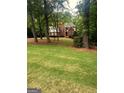 Beautiful front yard with mature trees surrounding a two-story brick home at 340 Antebellum Way, Fayetteville, GA 30215