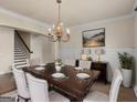 Elegant dining room with a hardwood table, chandelier, and wainscoting at 1225 Polk Xing, Mcdonough, GA 30252