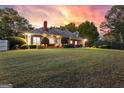 Expansive backyard with a well-maintained lawn, seating, and brick exterior at dusk at 248 Montrose Dr, Mcdonough, GA 30253
