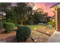 Lush backyard features manicured shrubbery, a stone pathway, and landscape lighting at 248 Montrose Dr, Mcdonough, GA 30253