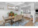 Bright dining room featuring a coffered ceiling, stylish chandelier, and an open floor plan at 445 Sawmill Trce, Hampton, GA 30228