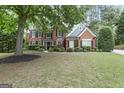 Beautiful brick home with a lush front lawn, accented by mature trees offering shade and curb appeal at 2770 Stonehill Way, Cumming, GA 30041