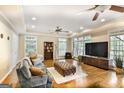 Bright living room with large windows, hardwood floors, and a cozy seating area with a television at 2770 Stonehill Way, Cumming, GA 30041
