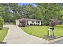 Well-maintained home with a long driveway, manicured lawn, and classic mailbox at 306 N Meade Dr, Peachtree City, GA 30269