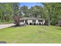 Attractive single-story house featuring a well-manicured lawn, trees, and landscaping at 306 N Meade Dr, Peachtree City, GA 30269