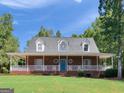 Inviting brick home featuring a full-width covered porch with white railings, perfect for enjoying the outdoors at 1302 Eddie Craig Ct, Mcdonough, GA 30252