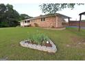 A well-manicured lawn surrounds the home, complemented by a lovely flower bed adding a touch of nature's beauty at 2647 Mount Carmel Rd, Hampton, GA 30228
