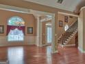 Open concept living space with gleaming hardwood floors, large window, and staircase at 187 Eagles Club Dr, Stockbridge, GA 30281