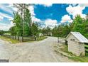 Long driveway with an electronic gate and rural surroundings at 107 Corinth Reserve Pl, Grantville, GA 30220