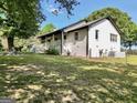 Side exterior of white brick home with a covered porch and manicured lawn at 701 Mask Rd, Brooks, GA 30205