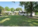 Charming white brick home with a lush green lawn and mature trees on a sunny day at 701 Mask Rd, Brooks, GA 30205