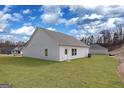 Spacious backyard with level lawn and white siding on home exterior, offering potential for outdoor activities at 442 Prescott Way, Villa Rica, GA 30180