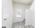 Inviting entryway featuring stylish wood-look flooring, a white front door with blinds, and access to the stairs at 467 Prescott Way, Villa Rica, GA 30180
