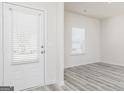 Bright entryway features a door with glass, a window, and stylish gray wood-look flooring at 443 Prescott Way, Villa Rica, GA 30180