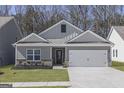 New construction featuring neutral gray siding and an inviting two-car garage at 445 Prescott Way, Villa Rica, GA 30180