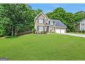 Two-story brick home with manicured lawn and landscaping, complemented by dark shutters and a two-car garage at 242 Greenland Dr, Mcdonough, GA 30253