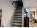 Stairway view to the second level, complemented by a light interior and wood flooring at 2353 Wellington Cir, Lithonia, GA 30058