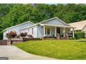 Charming single-story home with a welcoming front porch, lush landscaping, and a well-manicured lawn at 1928 Main Nw St, Atlanta, GA 30318