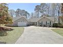 Exterior home view showcasing a well-maintained landscape, long driveway, attached garage, and inviting curb appeal at 200 Doe Run, Peachtree City, GA 30269