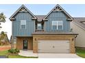 Inviting two-story home with a brick and siding exterior and a two-car garage at 2385 Aukerman Trce # 80, Hampton, GA 30228