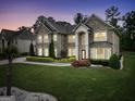 Evening view of a stately two-story brick home showcasing manicured landscaping and elegant architectural details at 3709 Royer Ln # 23, Hampton, GA 30228