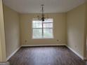 Spacious dining room featuring wood floors, a large window, and a stylish chandelier at 1119 Oakwood Manor Ct, Decatur, GA 30032