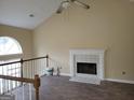 Bright living room with a cozy fireplace, vaulted ceiling, and natural light from the arched window at 1119 Oakwood Manor Ct, Decatur, GA 30032