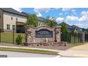 Stone community entrance sign with a water feature and wrought iron fencing at 1808 Quaker St, Hampton, GA 30228