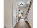 Entry hallway featuring wood floors, a staircase, and view of the front yard at 2373 Aukerman Trce # 83, Hampton, GA 30228