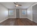 Clean bedroom features hardwood floors, neutral paint, multiple windows and ceiling fan at 59 S Old Hwy 27, Roopville, GA 30170
