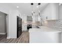 Bright modern kitchen with white cabinets, quartz counters, stainless appliances, and stylish backsplash at 5109 Dogwood Hills Dr, Sugar Hill, GA 30518
