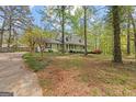 Quaint one-story home featuring a quaint front porch and mature trees at 130 Ashley Trace Dr, Locust Grove, GA 30248