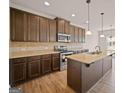 Spacious kitchen with dark wood cabinets, granite countertops, stainless steel appliances, and an island at 2381 Aukerman Trce # 81, Hampton, GA 30228